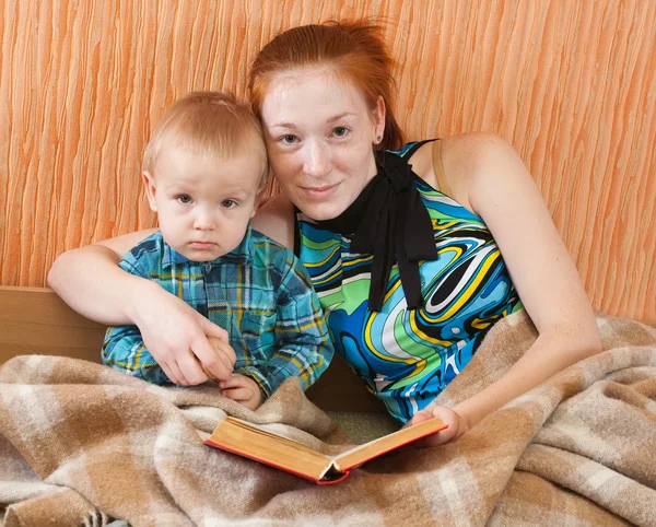 Mor med sonreading bok — Stockfoto