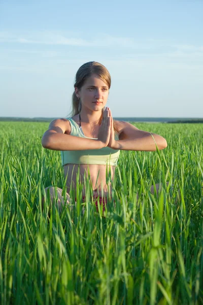 Girl practicing yoga against blue — Stock Photo, Image