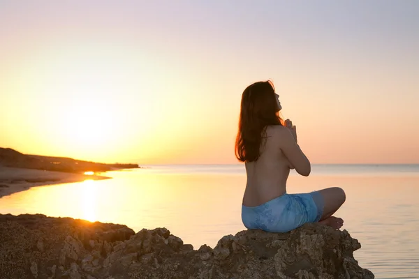 Flickan gör yoga mot solnedgången — Stockfoto