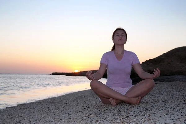 Günbatımı karşı yoga yaparken kız — Stok fotoğraf