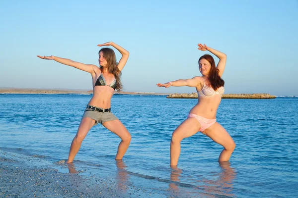 Девушки практикуют йогу на рассвете — стоковое фото