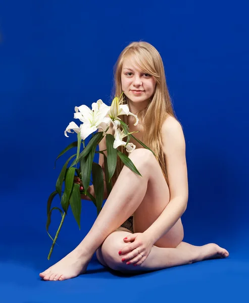 Sittande naken flicka med lily Stockfoto
