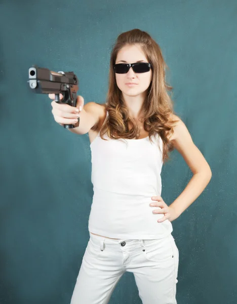 Meisje in zonnebril pogend een pistool — Stockfoto