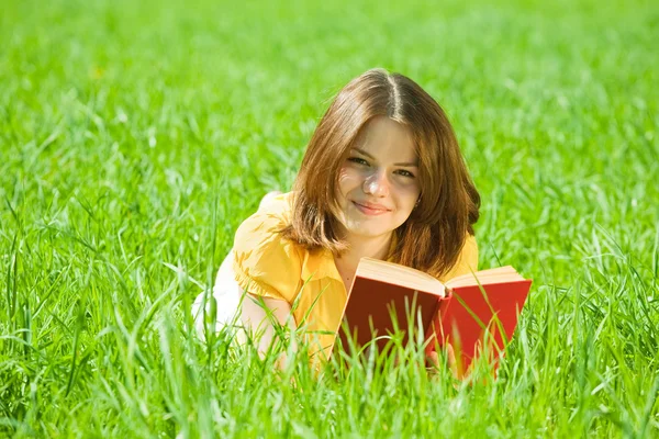 Menina livro de leitura na grama — Fotografia de Stock