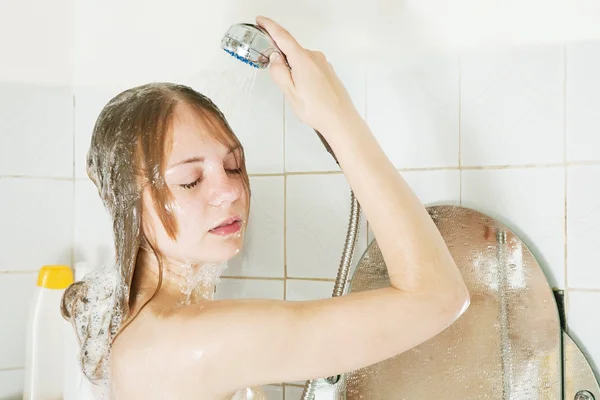 Shampooes menina com chuveiro — Fotografia de Stock
