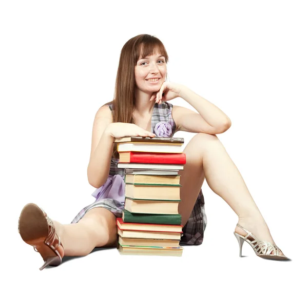 Студент сидит с грудой книг — стоковое фото