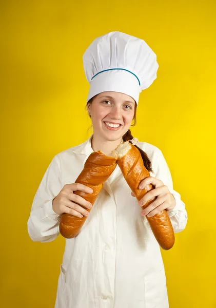 Пекарь держит длинные булочки — стоковое фото