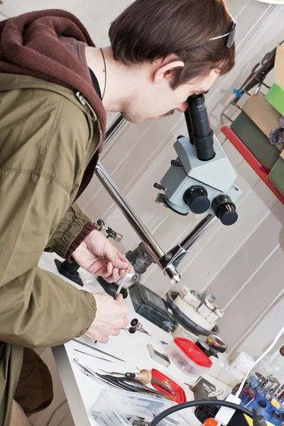 Joalheiro trabalhando com microscópio — Fotografia de Stock