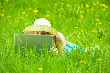 Girl with laptop in meadow clipart