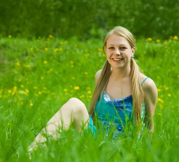 微笑在草丛中的金发女孩 — 图库照片