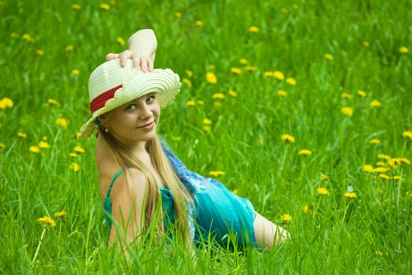 Menina no chapéu relaxante na grama — Fotografia de Stock