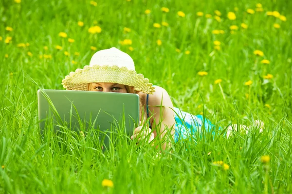 Menina com laptop no prado — Fotografia de Stock