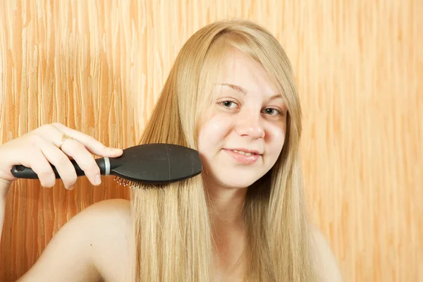Meisje haar lange haren kammen — Stockfoto