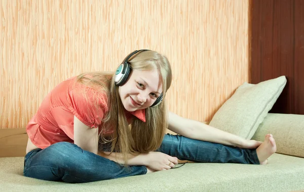Chica escuchando música en el sofá — Foto de Stock