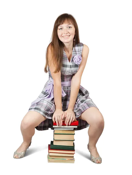 Kitap yığınının üzerinde oturan öğrenci — Stok fotoğraf