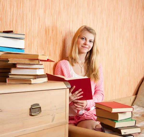 Chica con libros en el sofá —  Fotos de Stock