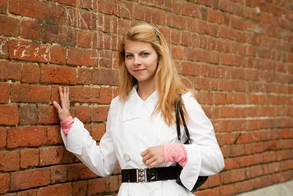 Chica cerca de pared de ladrillo rojo — Foto de Stock