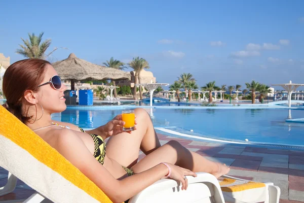 Menina com suco de laranja no hotel resort — Fotografia de Stock
