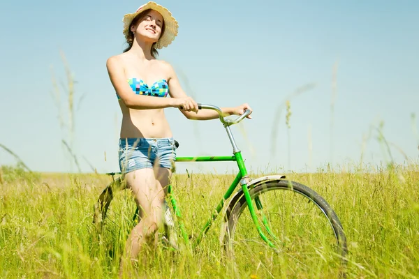 Menina com bicicleta na grama — Fotografia de Stock