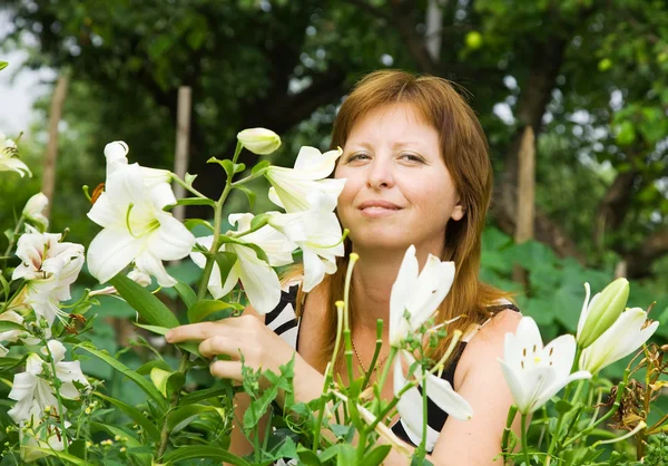 Vrouw met lelie in tuin — Stockfoto