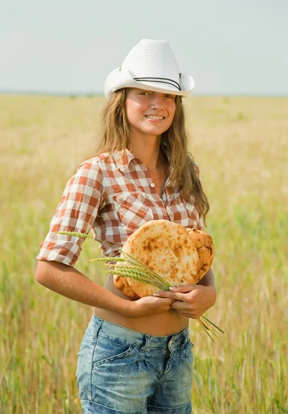 Chica con pan en el campo de cereales — Foto de Stock