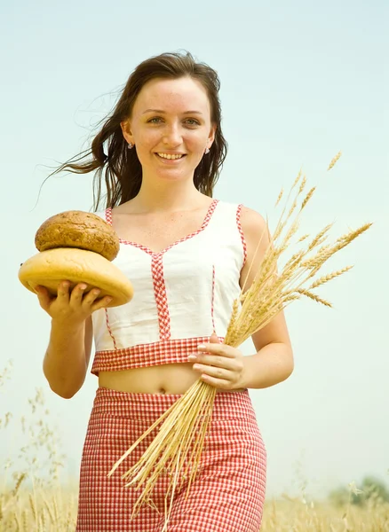 Flicka med bröd på fältet — Stockfoto