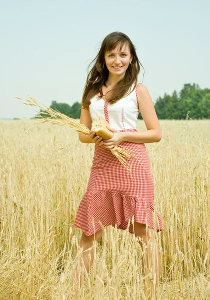 Flicka med bröd på fältet — Stockfoto
