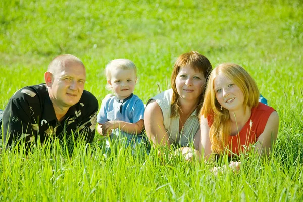 Família feliz na grama — Fotografia de Stock
