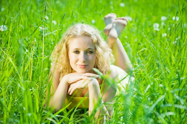 Menina loira repousa sobre a grama — Fotografia de Stock
