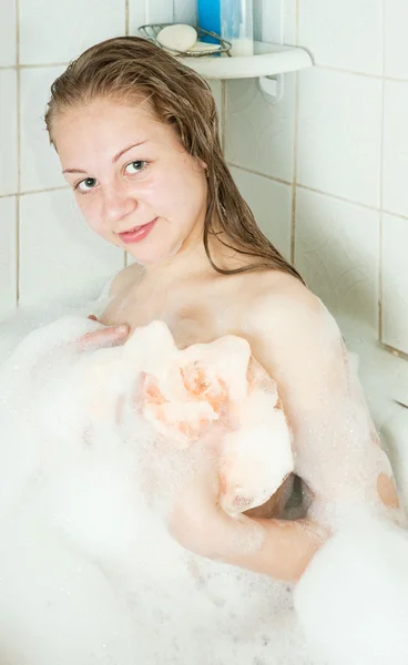 Дівчина розслабляється з піною у ванній — стокове фото
