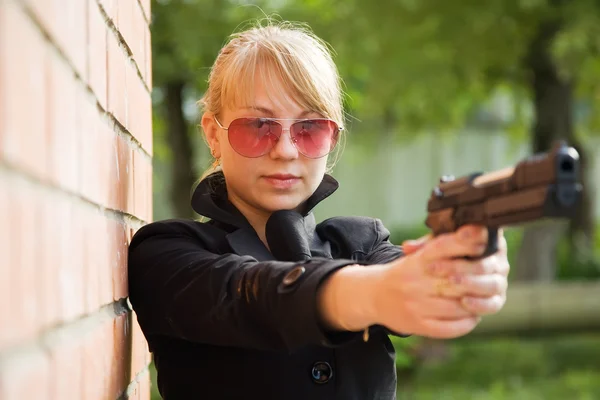 Frau zielte mit schwarzer Waffe — Stockfoto