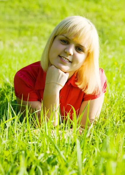 Girl in red lying on grass — Stock Photo, Image