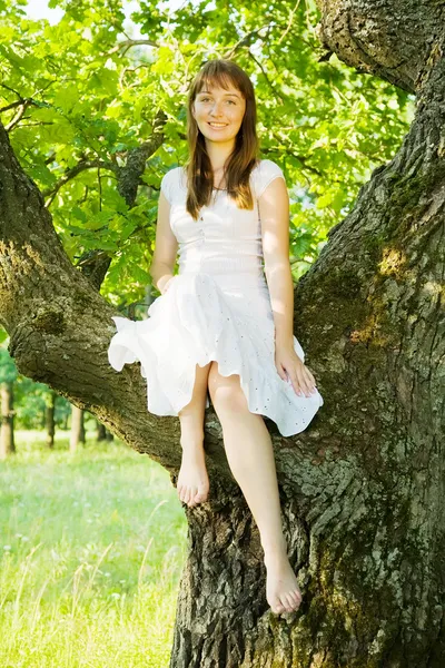 Chica sentada en el árbol — Foto de Stock