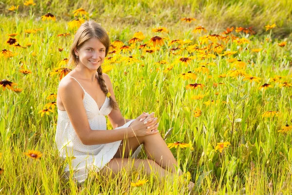 Dívka sedící v květech — Stock fotografie