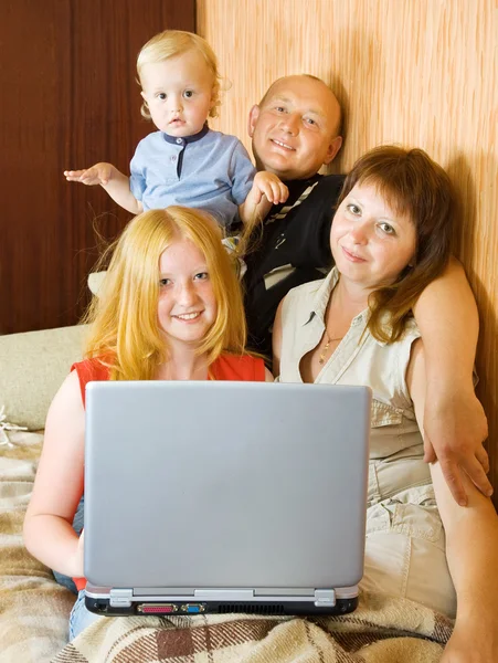 Familia usando el ordenador portátil en casa — Foto de Stock