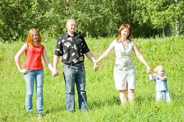 Family from four stands on grass — Stock Photo, Image