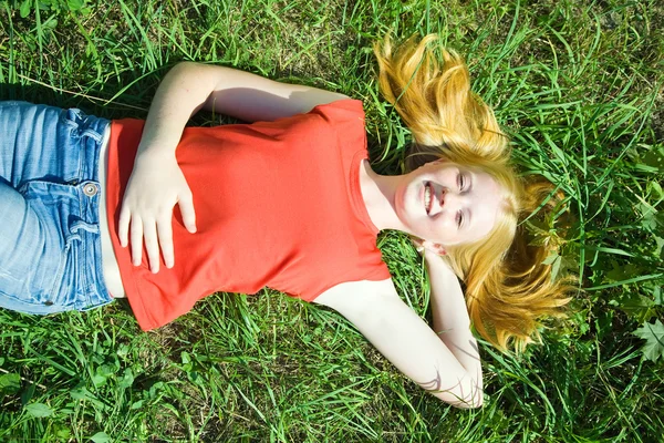 Tonåring flicka liggande i gräset — Stockfoto