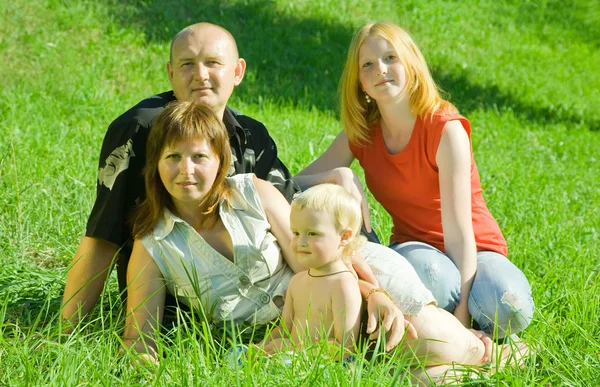 Çimenlerde poz veren dört kişilik aile. — Stok fotoğraf
