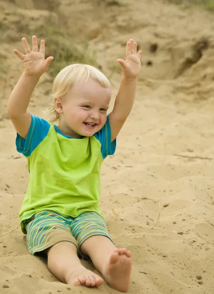Chlapce, který seděl na písku beach — Stock fotografie