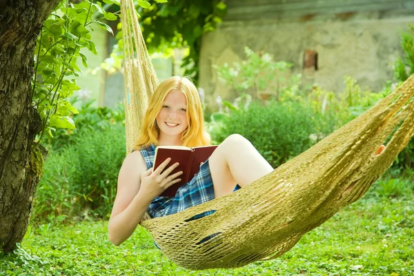 Meisje leesboek op hangmat — Stockfoto