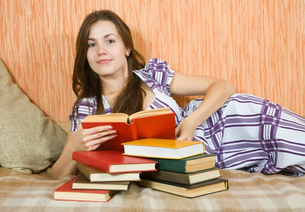 Flickan läsa bok om soffa — Stockfoto