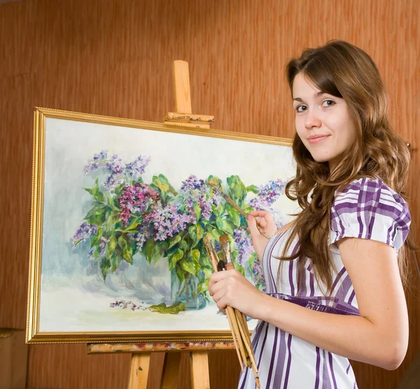 Girl with brushes near easel — Stock Photo, Image