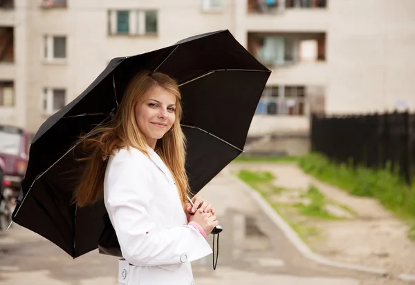 Дівчина в плащі з парасолькою — стокове фото