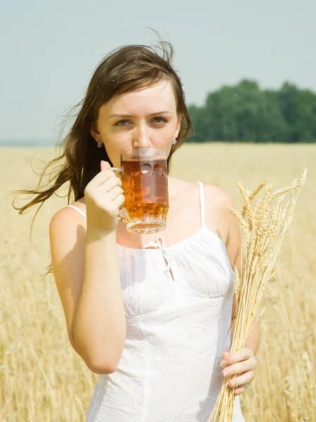 Девушка с пивом и пшеничным ухом — стоковое фото