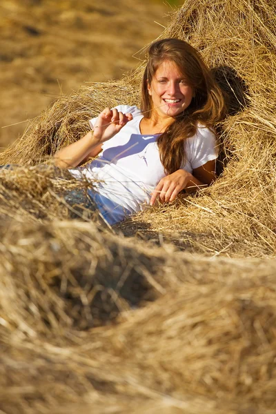 Girl laying on straw — Stock Photo, Image