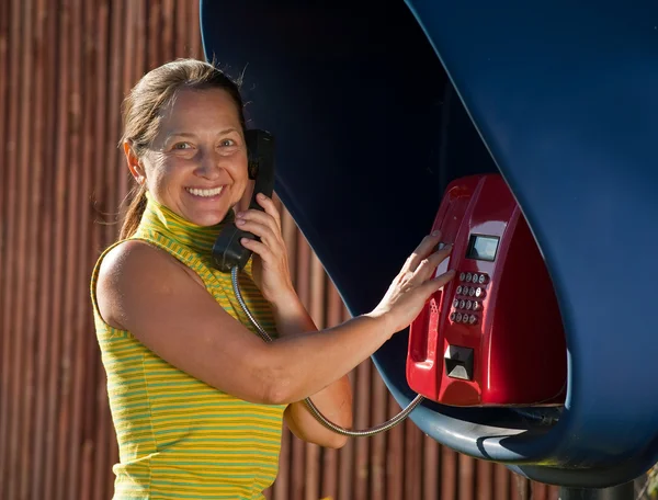 Senior woman on pay phone — Stock Photo, Image