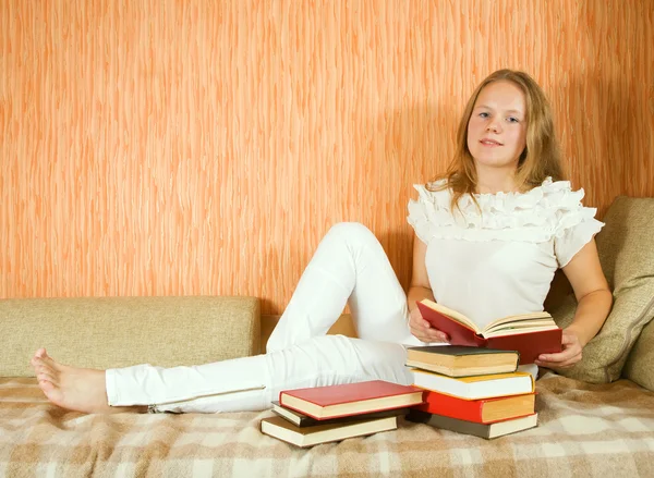 Dívka čtení knih na pohovce — Stock fotografie