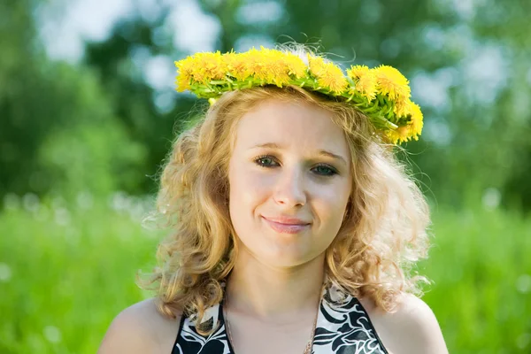 Girl in dandelion chaplet against nature — Stock Photo, Image
