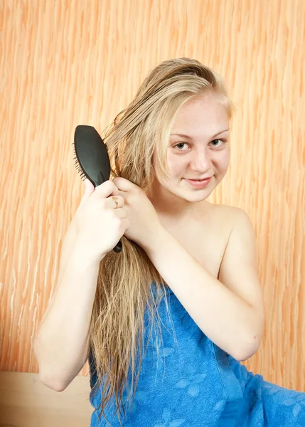 Meisje haar lange haren kammen — Stockfoto