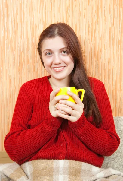 Woman relaxing at home with a cup — Stockfoto